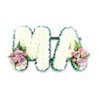 The photograph captures an elegant funeral flower arrangement forming the word MA, a loving salute that many families in Lea Bridge choose when saying goodbye to a mother or Mama. The two capital letters are set side by side on a plain white background, free from any distractions so that the focus stays on the craftsmanship and sentiment. A blanket of pure white chrysanthemums covers each letter, their small, rounded blooms overlapping one another to create a thick, soft surface with a gentle, almost satin sheen under the light. Around the edges, a narrow, pleated trim of deep green foliage or ribbon defines the shapes clearly, running neatly along every angle of the M and every slope of the A. This dark green trim not only frames the flowers but also hints at the nearby green spaces of Lea Bridge, from the canal banks to the edges of Hackney Marshes. At the lower left corner of the M and the lower right corner of the A, two matching floral accents rest like delicate brooches. Each is composed of pastel roses in shades of blush pink and pale lilac, gathered with smaller pink spray roses to add texture and depth. A few light fern fronds and sprigs of greenery project from beneath the petals, softening the composition and giving a natural, garden-like feel. The colour scheme remains gentle and restrained, creating a sense of calm and gratitude. This tribute would be perfectly at home at a local chapel or crematorium service, offering a quiet expression of love and remembrance from a family rooted in the Lea Bridge community.