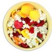 A top-down view captures a round, light yellow ceramic bowl filled entirely with an opulent mix of loose petals, a quiet floral gesture suited to a funeral or memorial in Lea Bridge. The bowl cradles a rich scattering of roses in deep crimson red, glowing sunflower yellow, and tender peach-apricot, each petal thick and velvety, some folded inward, others splayed open to catch the light. Between these warm tones, delicate clusters of tiny white hydrangea florets are threaded generously throughout, their papery, ruffled petals creating a soft, cloud-like contrast and adding a sense of purity and peace. The petals appear freshly picked and gently placed, not in rigid rows but in relaxed, overlapping layers that create a natural, comforting texture, as though they've been gathered from wreaths and sprays after a farewell service. Gentle light from above brings out the subtle sheen on the rose petals and the matte softness of the hydrangea, while the pale rim of the bowl quietly frames the colour within without distraction. You can almost sense the mixed fragrance-sweet, floral, and calming-rising from the arrangement, ready to lend comfort in a quiet chapel, a family home near Lea Bridge Road, or a small remembrance gathering. This simple yet heartfelt bowl of petals feels like an intimate tribute, a tender way to honour memories and offer unspoken sympathy.